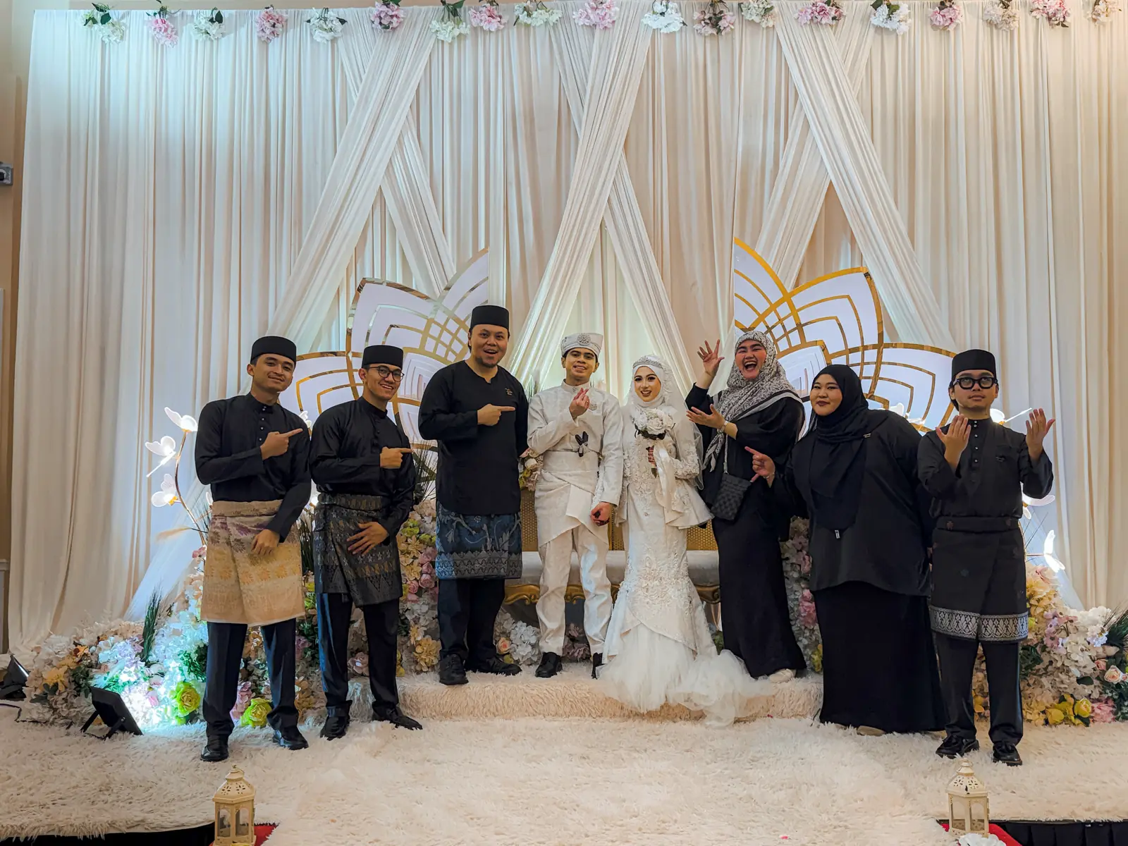 Six Agendas Brunei crew with a bride and groom on a white draped pelamin